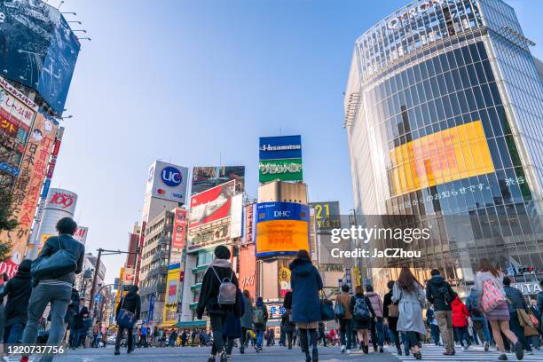 pedestres atravessando a rua em shibuya cruzamento com borrão de movimento - distrito de shibuya - fotografias e filmes do acervo