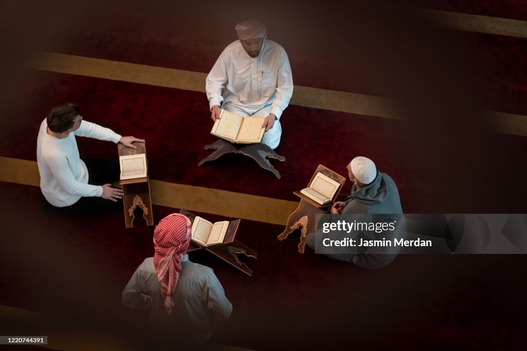 Muslim adults learning Koran together in mosque