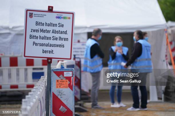 Medical workers prepare to accept scheduled visitors for throat swabs at a drive-in and walk-in Covid-19 testing facility in Neukoelln district...