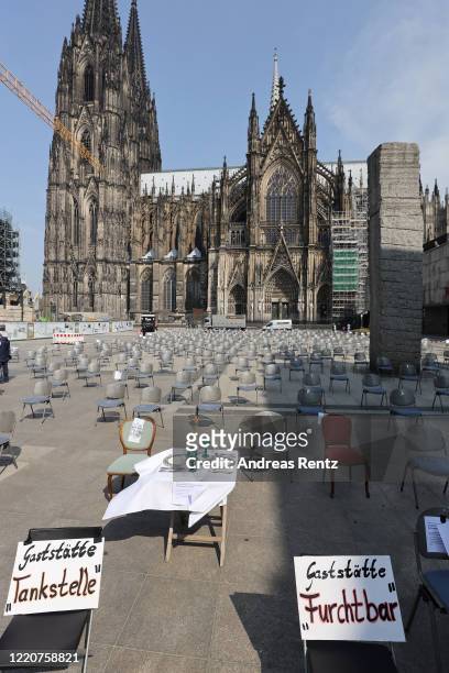 Set dining table and restaurant chairs stand arranged in front of the Cologne Cathedral during a nationwide protest by restaurateurs during the novel...