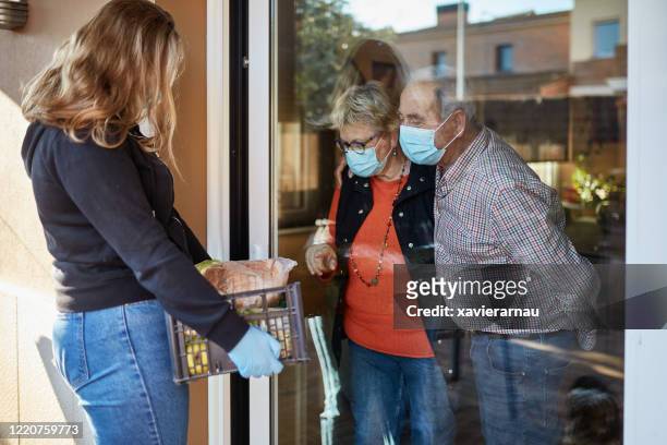 volunteer delivers groceries to senior couple during pandemic - quarantine stock pictures, royalty-free photos & images