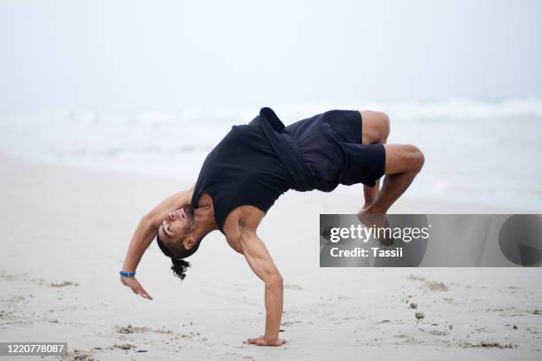 good dancers are those who master strength and balance - hunky guy on beach stock pictures, royalty-free photos & images