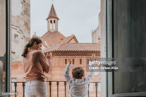 family applauding to the medical staff from the balcony for covid-19 - applauding balcony stock pictures, royalty-free photos & images