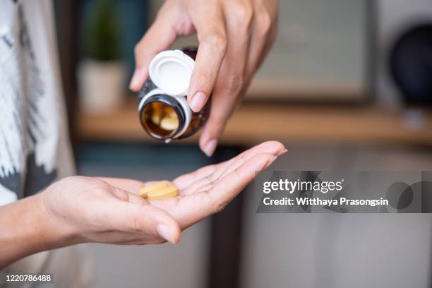 man taking vitamins and supplements - nutritional supplement fotografías e imágenes de stock