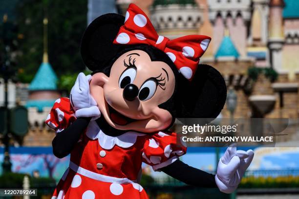 Cast member dressed as cartoon character Minnie Mouse takes part in the official reopening ceremony of Hong Kong's Disneyland on June 18 following...