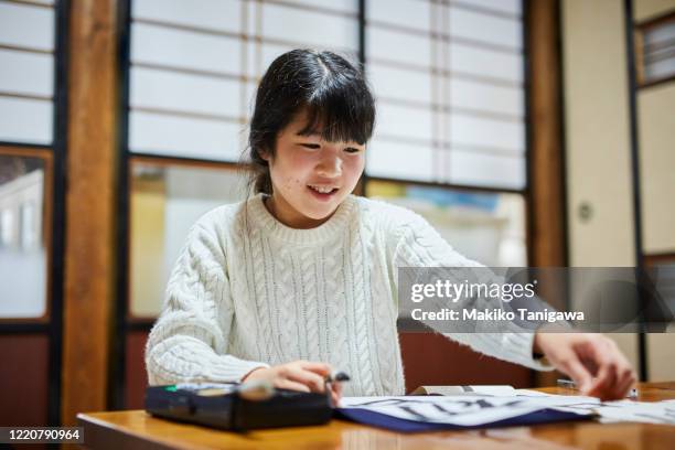 japanese girl doing kakizome - japanese calligraphy stock pictures, royalty-free photos & images