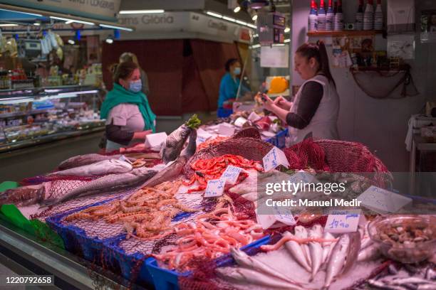 Fishmonger serves a customer in the Santa Caterina market on April 24, 2020 in Barcelona, Spain. The Santa Caterina market is one of the main and...