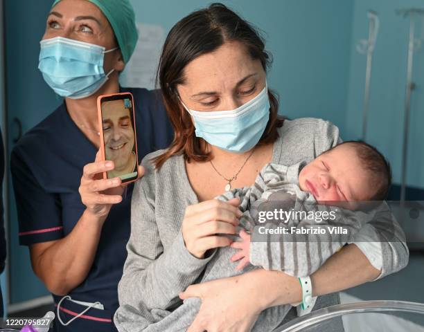 Annamaria Scarcella is assisted by a nurse as she shares a video call with newborn son Giovanni and the father in Cannizzaro Hospital on April 24,...