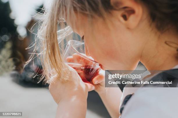 girl drinking juice - niño-tomando-agua fotografías e imágenes de stock