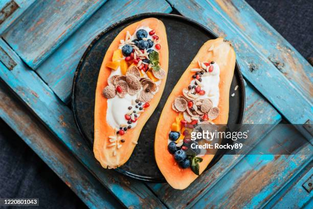 deliziose papaya boat - il nuovo tipo di ciotole per la colazione - papaia foto e immagini stock