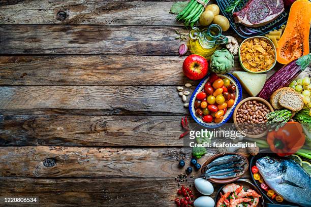 food backgrounds: large variety of food on rustic wooden table. copy space - food pyramid stock pictures, royalty-free photos & images