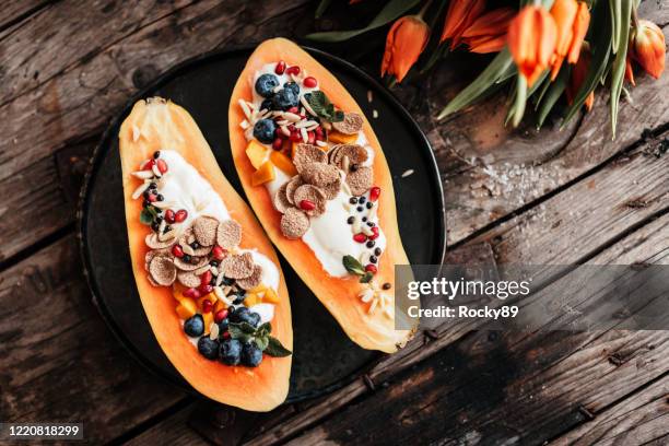 vegan papaya boats – the new kind of breakfast buddha bowls - papaya stock pictures, royalty-free photos & images