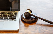 Judge gavel and a laptop, wooden background. Online auction concept