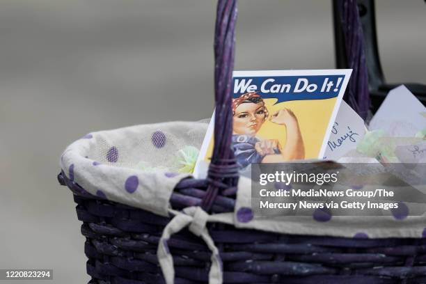 Basket containing Rosie the Riveter cards and candy are placed on a table next to Mary Fierros in front of her home during a parade celebrating her...