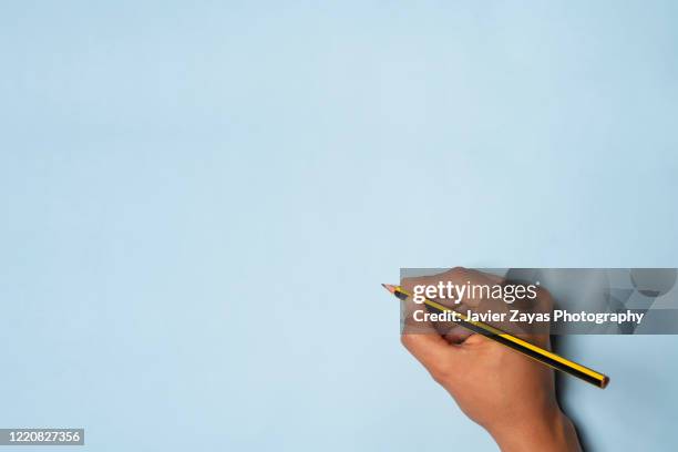 hand holding a yellow and black pencil - pencil stock pictures, royalty-free photos & images