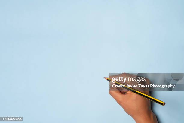 hand holding a yellow and black pencil - human hand drawing stock pictures, royalty-free photos & images