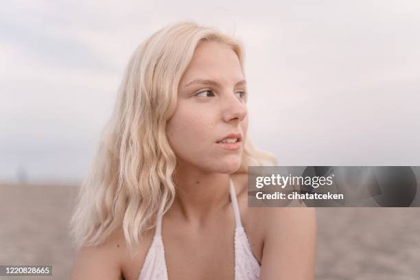 aantrekkelijke blonde vrouw die voor foto op strand stelt - no make up stockfoto's en -beelden