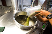 Beer Brewer adding hops to beer stainless steel tank