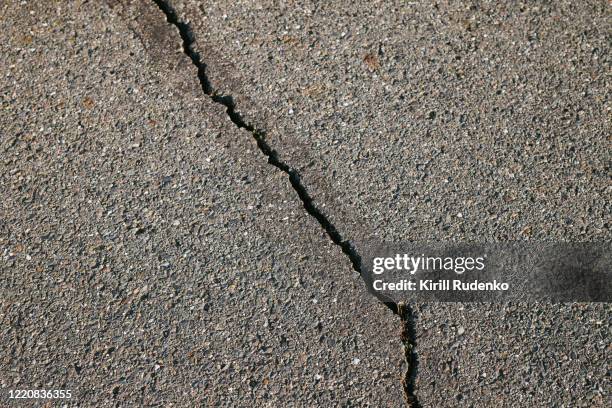 crevice on asphalt road - earthquake road stock pictures, royalty-free photos & images