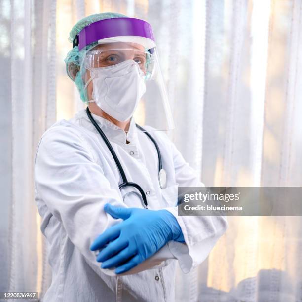 female medical worker wearing protective face mask - macacão de limpeza imagens e fotografias de stock