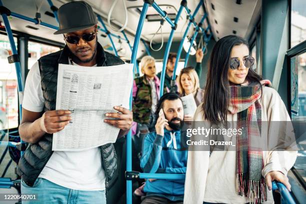 afrikaanse amerikaanse werkloze die krant leest en vacature zoekt - bus advertising stockfoto's en -beelden