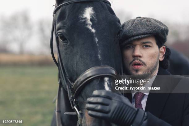 equestrian holding horse and looking at camera - guanto di pelle foto e immagini stock