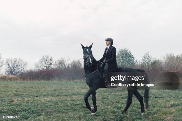 man in suit horseback riding. - men costume black and white stock-fotos und bilder