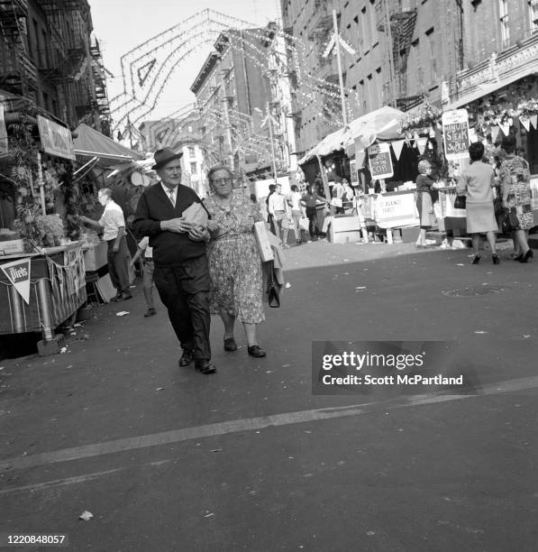 View of a senior couple walking along Mulberry Street during the Feast Of San Gennaro Festival, in the Little Italy neighborhood, New York, New York,...