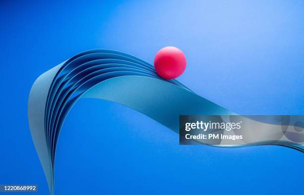 red ball riding paper wave - paper ball stock-fotos und bilder