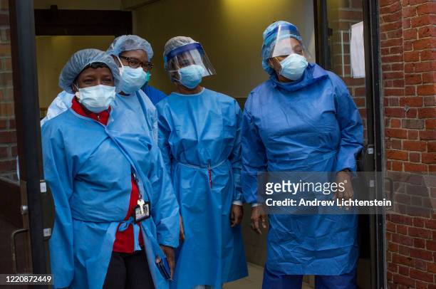 Kings County Hospital staffers wearing protective masks stand outside the hospital during the 7pm salute to healthcare workers amid the COVID-19...