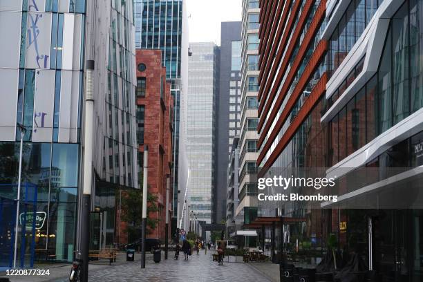 Pedestrians pass along a walkway between high-rise buildings in the Zuidas financial district in Amsterdam, Netherlands, on Thursday, June 18, 2020....