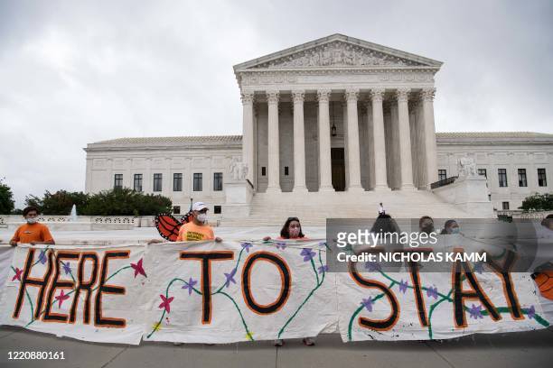 Activists hold a banner in front of the US Supreme Court in Washington, DC, on June 18, 2020. - The US Supreme Court rejected President Donald...