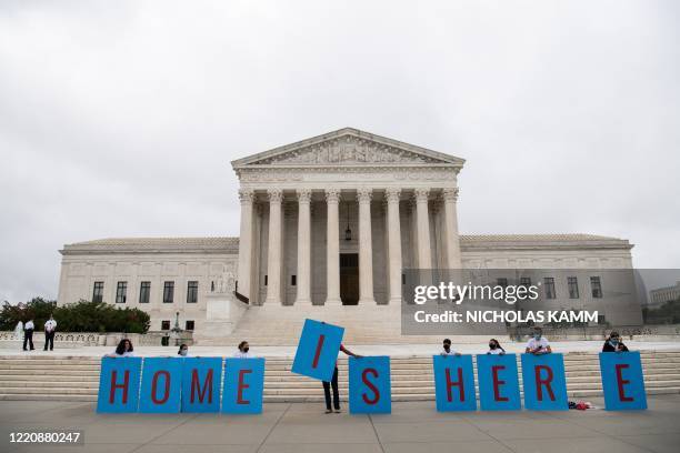 Activists hold a banner in front of the US Supreme Court in Washington, DC, on June 18, 2020. - The US Supreme Court rejected President Donald...