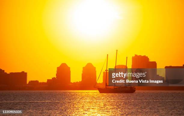 yacht against buildings at sunset - kendall stockfoto's en -beelden