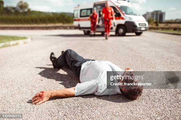 man die op de grond ligt na het letsel - gory car accident fotos stockfoto's en -beelden