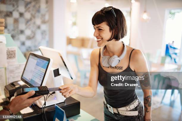 latina woman paying with credit card in cafe, ordering take out food - pos stock pictures, royalty-free photos & images