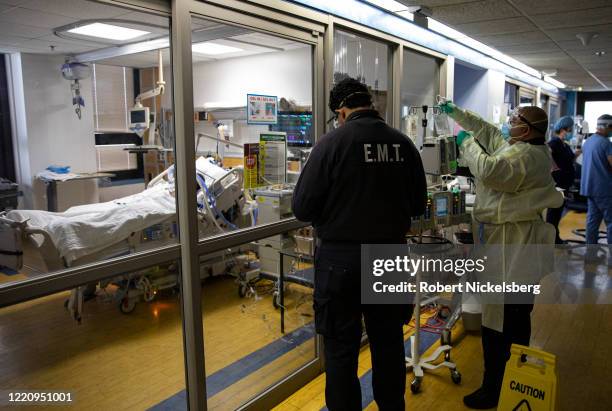 Two Emergency Medical Team technicians prepare to transfer a COVID-19 patient on the Medical Intensive Care Unit floor, MICU, to the Brooklyn VA...