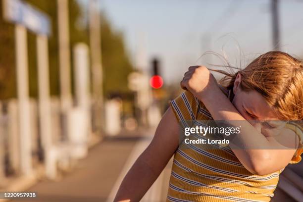 blonde dochter bij een treinstation - sneezing stockfoto's en -beelden