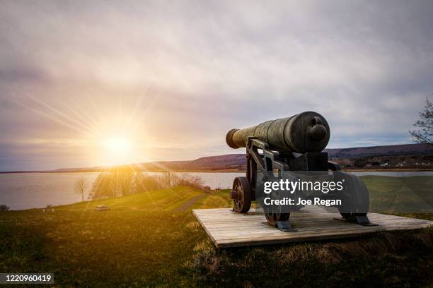 cannon pointing at setting sun. - artillery stock pictures, royalty-free photos & images