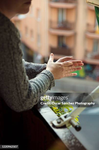 clapping hands from the balcony during the quarantine in spain - applauding balcony stock pictures, royalty-free photos & images