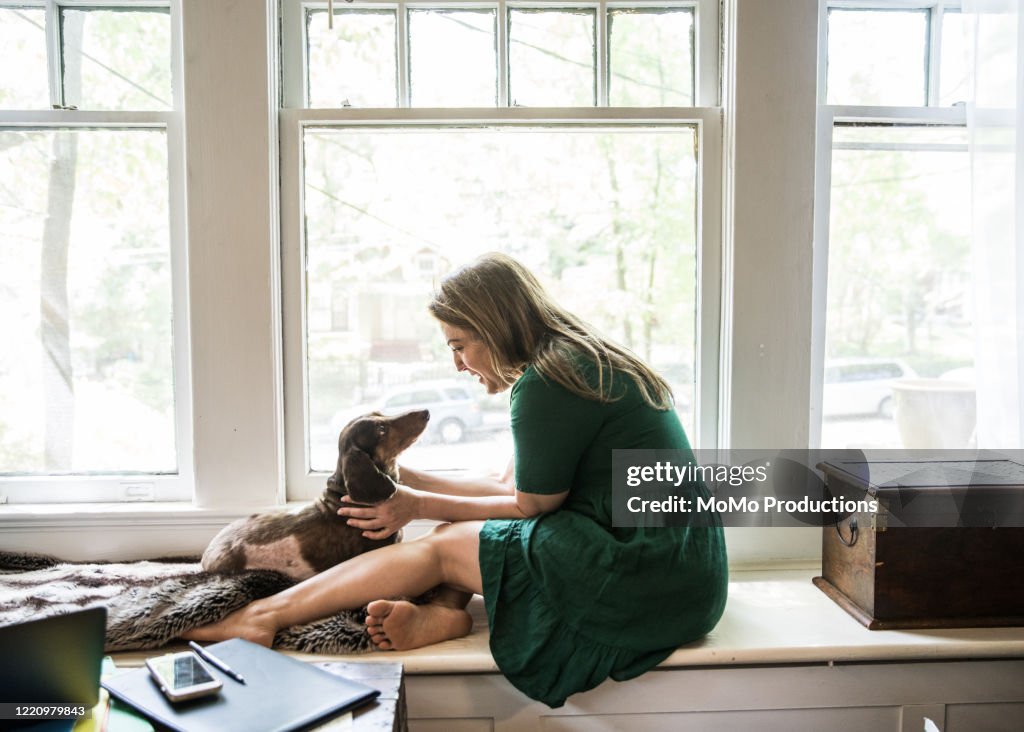 Woman sitting in window with dog