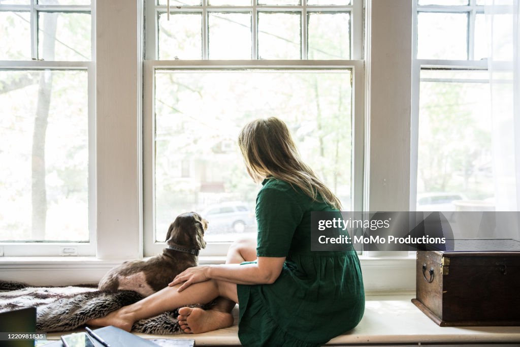 Woman sitting in window with dog