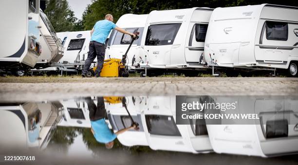 An employee checks the caravans at a dealer ship in Almere on June18 as sales of caravans and motorhomes has increased due to the novel coronavirus,...
