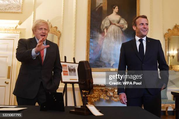 British Prime Minister Boris Johnson and French President Emmanuel Macron look at documents and artefacts related to former French president Charles...