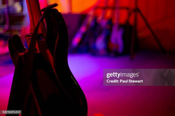 back of a bass guitar on a lit stage - bassgitarre stock-fotos und bilder