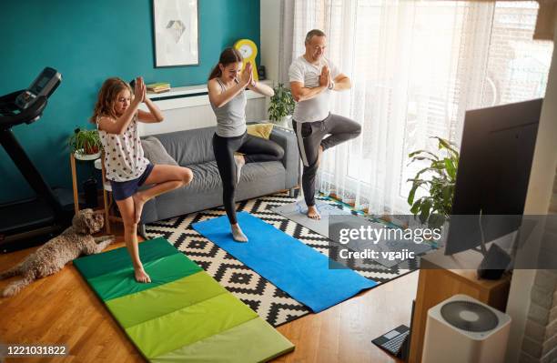 family practicing yoga at home with online classes - family online stock pictures, royalty-free photos & images