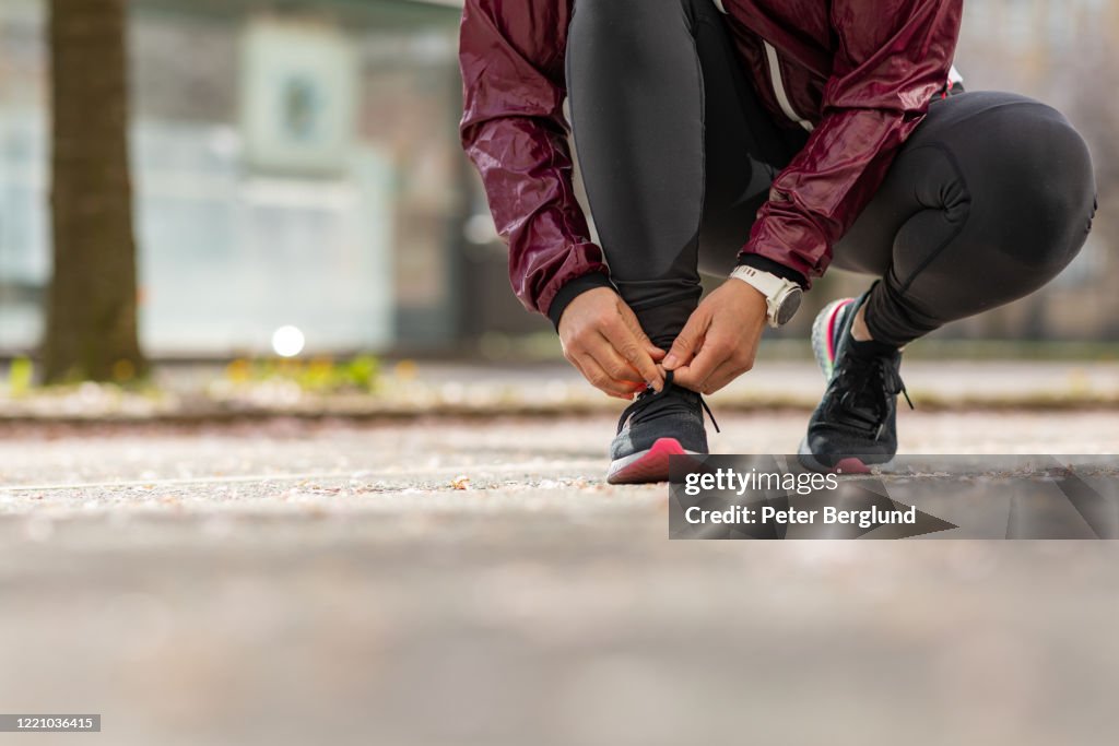 Vrouw die haar sportenschoenen bindt