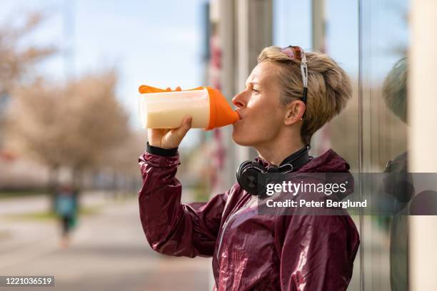 kvinna dricker en proteinshake - shaking bildbanksfoton och bilder
