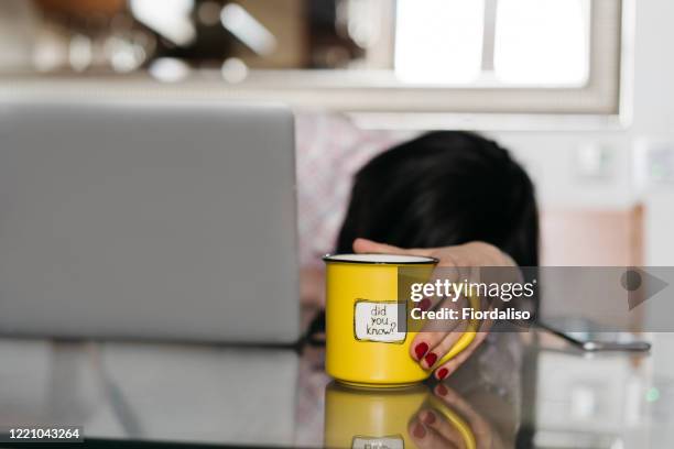 a middle-aged woman sitting in the kitchen at the glass table - did you know stock pictures, royalty-free photos & images