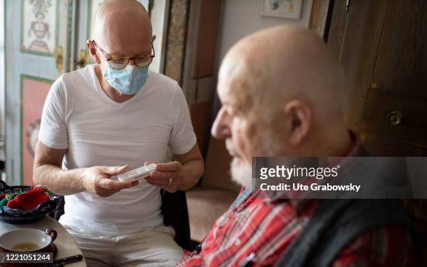 In this photo illustration a geriatric nurse controls the tablet intake of a patient on June 11, 2020 in Bonn, Germany.